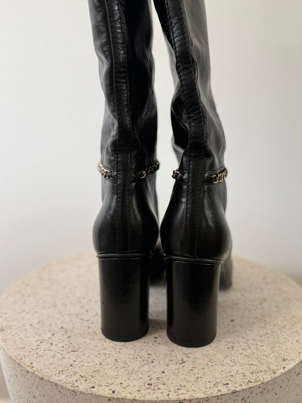 Chanel leather tall boots with a gold CC chain detail and block heel