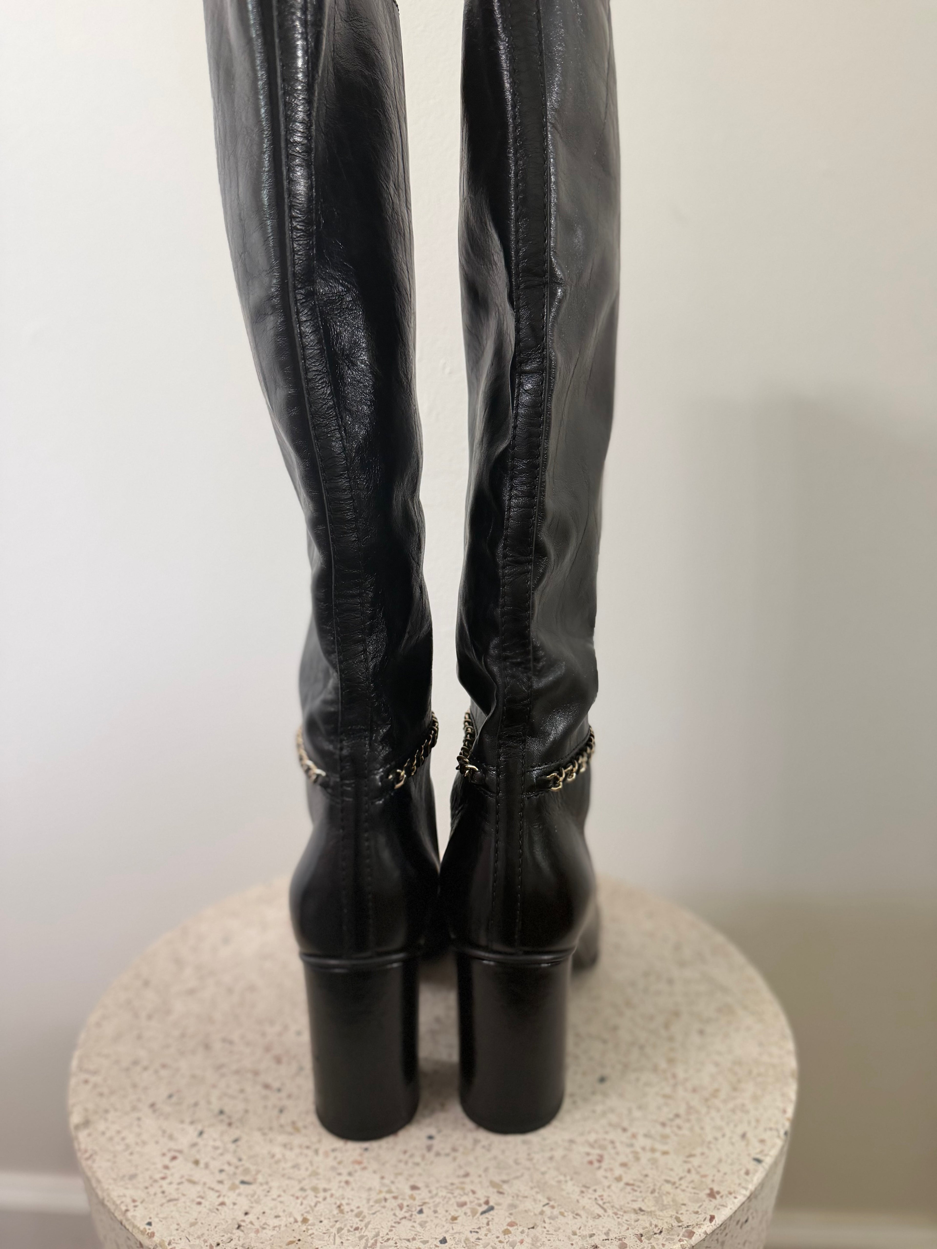 Chanel leather tall boots with a gold CC chain detail and block heel