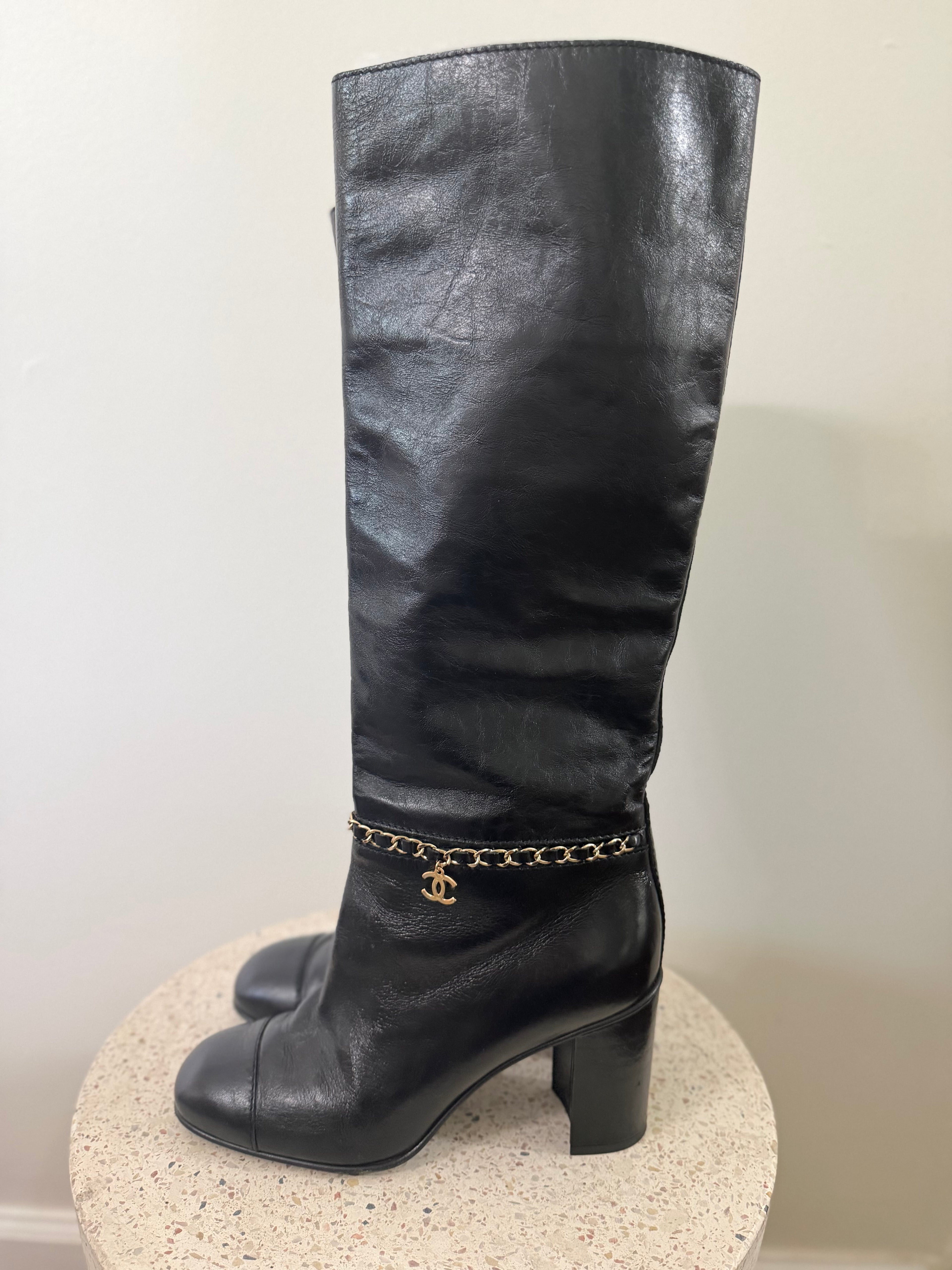 Chanel leather tall boots with a gold CC chain detail and block heel